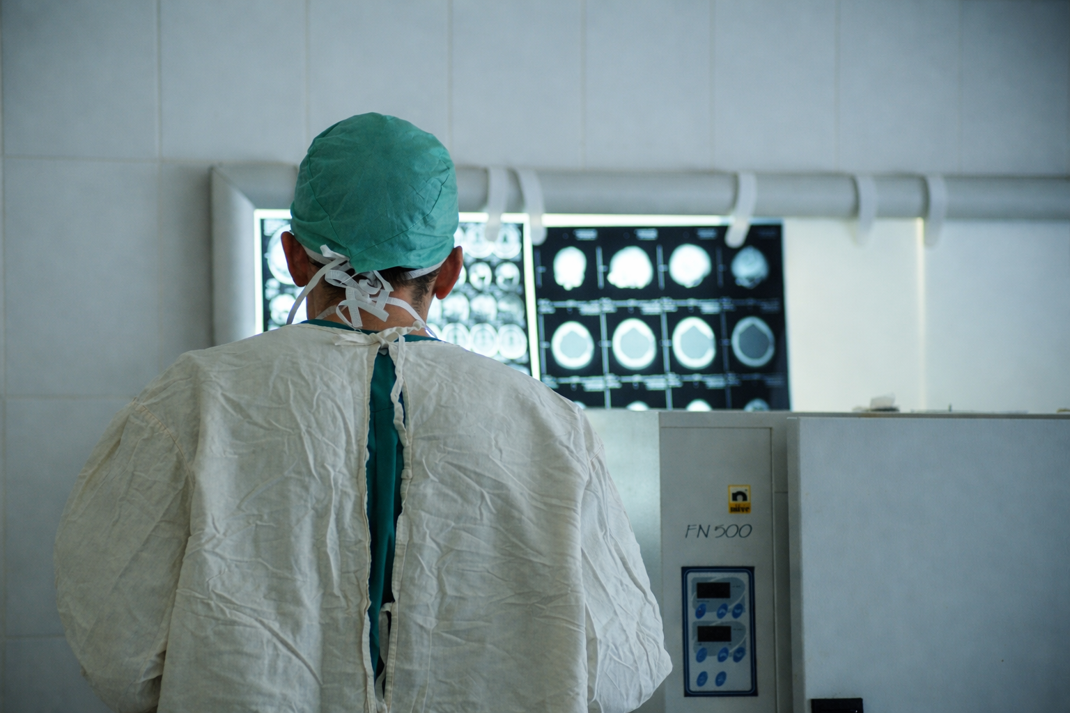 doctor in surgical attire reviews x-ray films